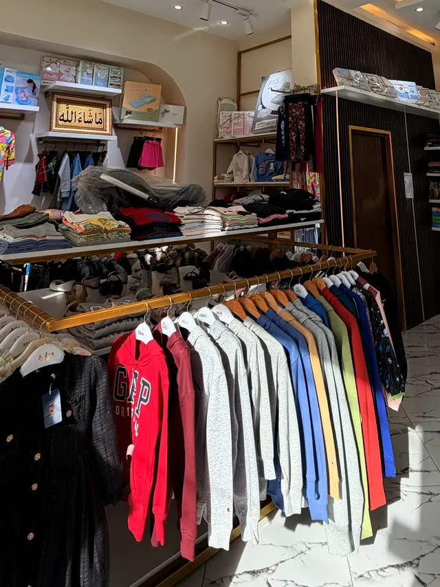 Racks of colorful hoodies and sets under the gold rail